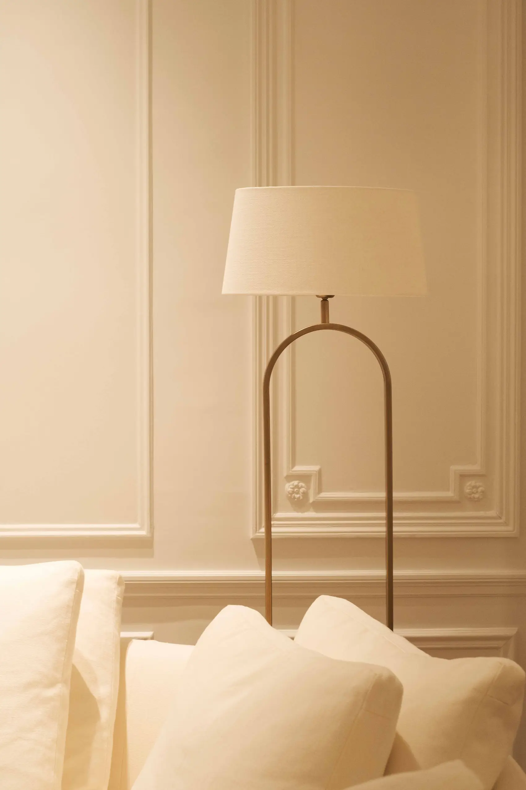 Lampadaire en arche façonné à la main, dans un salon aux moulures claires