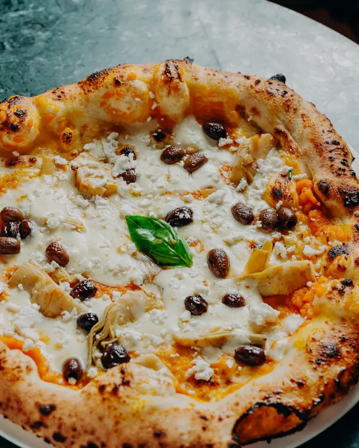Pizza aux artichauts, olives noires et fromage frais