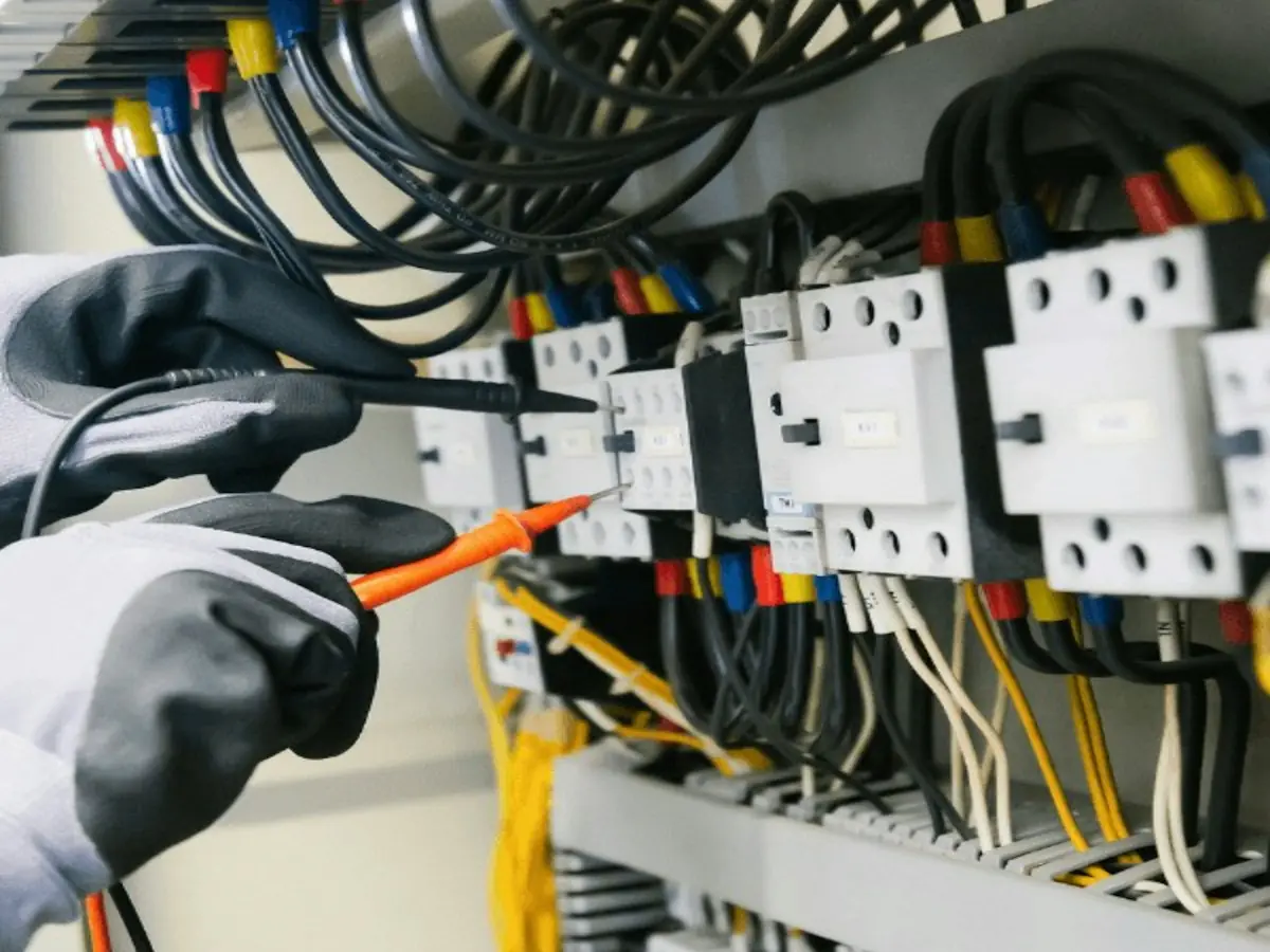 Électricien mesurant un circuit au testeur